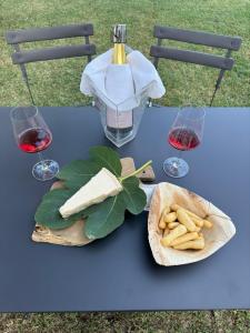 a table with a bottle of wine and a plate of food at Viotti Guest House in Castel Rocchero