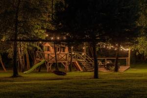 a playground in a park at night with a slide at Wisienka 25 - Dom z strefą spa i kinem in Nowy Sącz