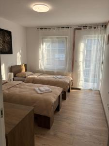 a room with three beds and a window at Vila Galerija in Vukovar