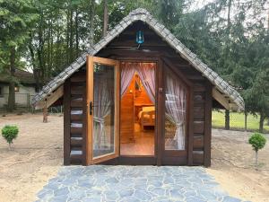 a small wooden shed with a door in a yard at Bungalow Bay -2 domki 4 osoby in Łacha