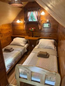 two beds in a small room with a window at Bungalow Bay -2 domki 4 osoby in Łacha