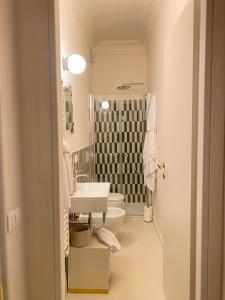 a white bathroom with a sink and a toilet at La Dimora di Pindaro in Colledimacine