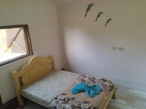 a small bedroom with a bed with a blue bow on the wall at Pousada Sítio do Aconchego Porto Feliz in Pôrto Feliz +20 photos