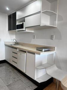 a kitchen with white cabinets and a counter top at Lake Side Resort Flat Beira Lago 5 minutos do centro de Brasília in Brasília +17 photos