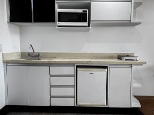 a kitchen with a sink and a microwave at Lake Side Resort Flat Beira Lago 5 minutos do centro de Brasília in Brasília