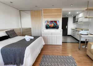 a bedroom with a bed and a tv in a room at Lake Side Resort Flat Beira Lago 5 minutos do centro de Brasília in Brasília