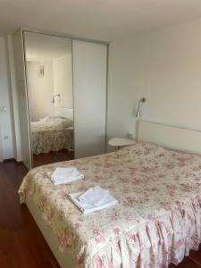 a bedroom with a mirror and a bed with towels at Apartments Villa Dinka in Opatija