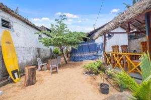 a patio with chairs and a surfboard next to a building at The Baysura Arugambay in Arugam Bay