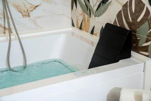 a bath tub filled with water in a bathroom at La Bella Ostuni Suites in Ostuni