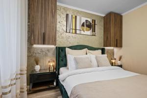 a bedroom with a bed with a green headboard at Awesome Apartment Bucharest in Bucharest