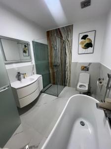 a bathroom with a tub and a sink and a toilet at Luxury Central Bucharest in Bucharest