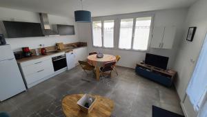 a kitchen with a table and a kitchen with white cabinets at Les Geais Bleus in Royan +15 photos
