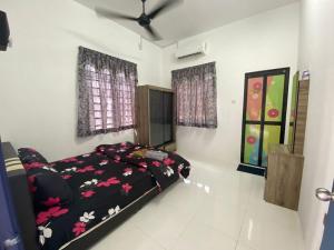 a bedroom with a bed with a black comforter at Akif Stella Guesthouse in Marang