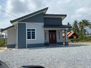 a small blue and white house with a driveway at Akif Stella Guesthouse in Marang