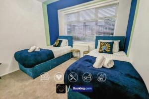 a bedroom with two beds and a window at Modern 4-Bed House, Free Parking & WiFi in Swinton in Manchester