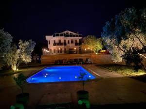 a swimming pool in front of a house at night at Nefes URLA Villa in Urla