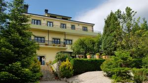 a large yellow building with a staircase in front of it at Hotel A Lastriña in Trives