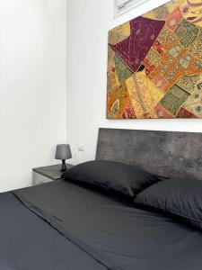 a bedroom with a bed and a painting on the wall at Casa vacanze Tramontana Salentina in Lendinuso