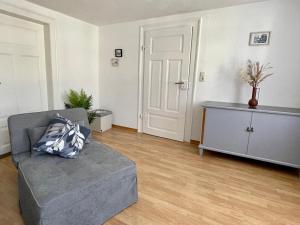 ワイマールにあるFerienapartment Weimar Altstadt 2のリビングルーム(グレーのソファ、キャビネット付) +1枚の写真