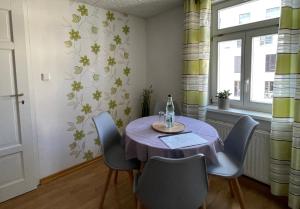 a dining room with a table with a bottle of wine at Ferienapartment Weimar Altstadt 2 in Weimar