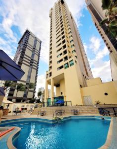 a large swimming pool in front of a building at Flat 10 andar Hotel Costa Mar acesso direto praia in Recife