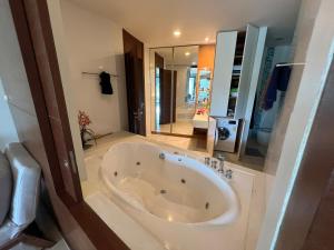a large white bath tub in a bathroom at Ananya Beachfront Wongamat Paradise in North Pattaya