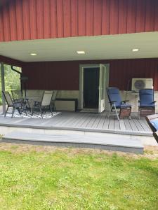 two chairs and a table on a deck next to a building at Lägenhet Bolum 7 in Broddetorp