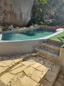 a swimming pool with stairs leading into a pool with blue water at Chale Tupi in Trindade