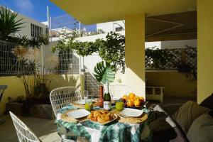 a table with a plate of fruit and a bottle of wine at Apartment La Perla, Los Cristianos in Los Cristianos