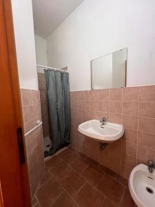 a bathroom with a sink and a mirror and a shower at Ostello Paradiso EuroCamp in Cesenatico