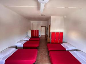 a room with three beds with red cushions at Ostello Paradiso EuroCamp in Cesenatico