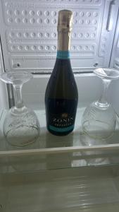 a bottle of wine and two glasses in a refrigerator at Sibejdo 3&4 in Varaždin