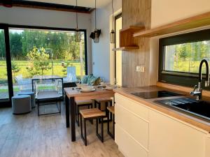 a kitchen and dining room with a table and chairs at Domki Na Łące in Święta Katarzyna