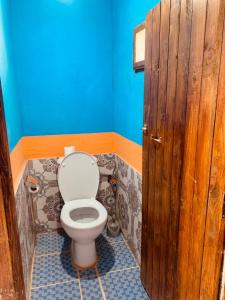 a bathroom with a toilet and a wooden door at maison traditionnelle in Merzouga
