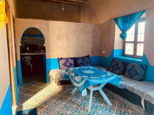 a room with a table in a room with blue walls at maison traditionnelle in Merzouga