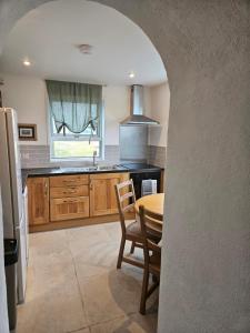 Achill Island Holiday home by the Sea - Idyllic views, Sleeps 6, Full kitchen, Fireplace and Wifi throughout في Achill Sound: مطبخ مع طاولة وغرفة طعام +28 صورة