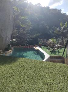 a swimming pool in the middle of a yard at Chale Tupi in Trindade +26 photos