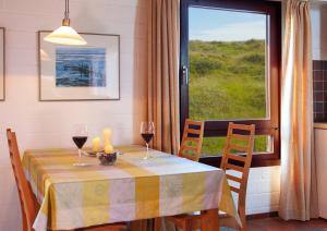 a table with two glasses of wine and a window at Ferienhaus Dübbel Norderney in Norderney