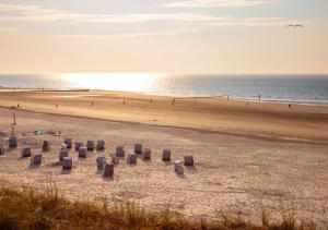 a beach with a group of boxes in the sand at Ferienhaus Dübbel Norderney in Norderney