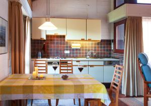 a kitchen with a table with a yellow table cloth at Ferienhaus Dübbel Norderney in Norderney