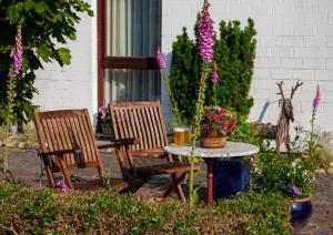two chairs and a table with flowers on a patio at Ferienhaus Dübbel Norderney in Norderney