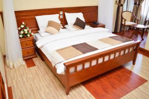 a bedroom with a large bed with a wooden headboard at Red Ruby Hotel in Nairobi