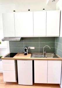 een keuken met witte kasten en een spoelbak bij Collet Résidence in Nice