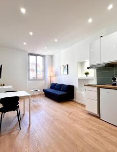 een woonkamer met een blauwe bank en een tafel bij Collet Résidence in Nice