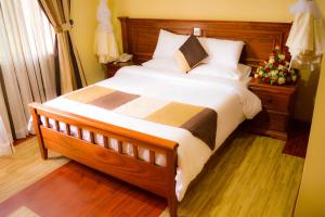 a large bed in a bedroom with a christmas tree at Red Ruby Hotel in Nairobi