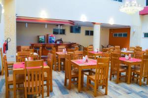 a restaurant with wooden tables and chairs with pink napkins at Red Ruby Hotel in Nairobi
