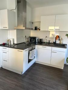 a kitchen with white cabinets and a black counter top at Mintara Apartment Charme der Stadt Parkplatz Netflix und Sky in Lichtenfels