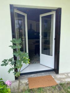 an open door of a house with a porch at Appartement avec jardin in Le Porge