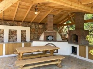 an outdoor patio with a table and a fireplace at Villa Noble in Faralya