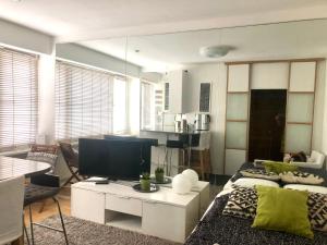 uma sala de estar com um sofá e uma TV em Kamppi Sweet Studio 07 em Helsínquia mais 16 fotografias